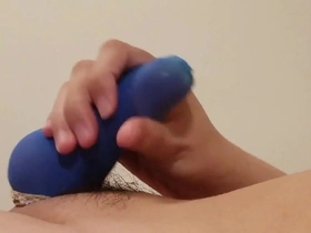 Gay man masturbates with a blue penis stocking on his cock.