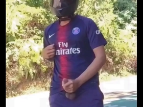 A solo act of a football player in a biker leotard outdoors in public.