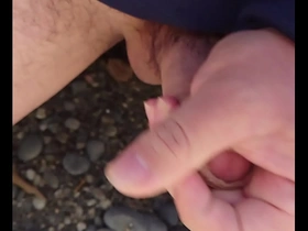 Gay Japanese man masturbates outdoors and cums on the beach.